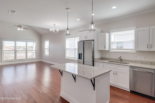 kitchen with stainless steel appliances, a breakfast bar, open floor plan, and white cabinetry