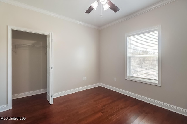 unfurnished bedroom with a closet, dark wood-style flooring, ornamental molding, and baseboards