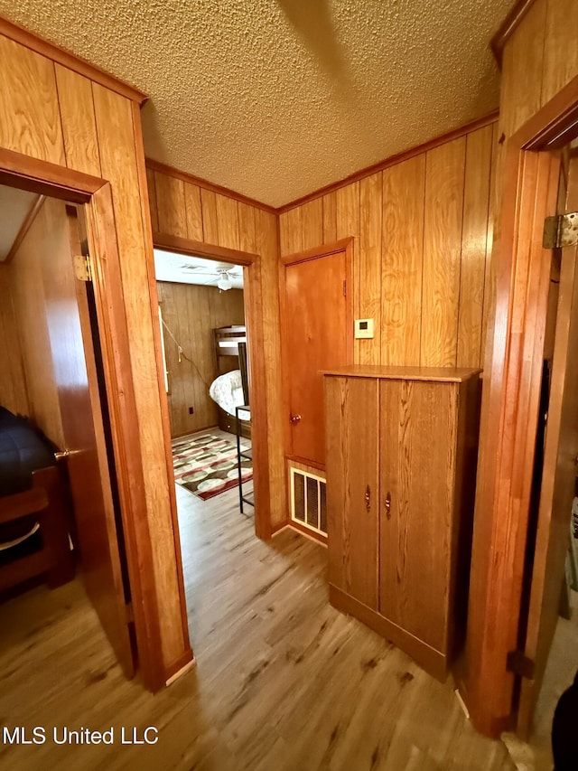 126 Lyon Dr, Grenada, MS 38901 - corridor with ornamental molding, light hardwood / wood-style floors, a textured ceiling, and wood walls