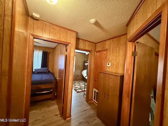126 Lyon Dr, Grenada, MS 38901 - hallway with light hardwood / wood-style flooring, ornamental molding, a textured ceiling, and wood walls