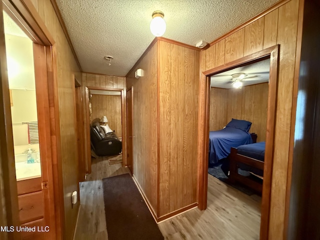126 Lyon Dr, Grenada, MS 38901 - hall featuring wooden walls, a textured ceiling, and light hardwood / wood-style floors