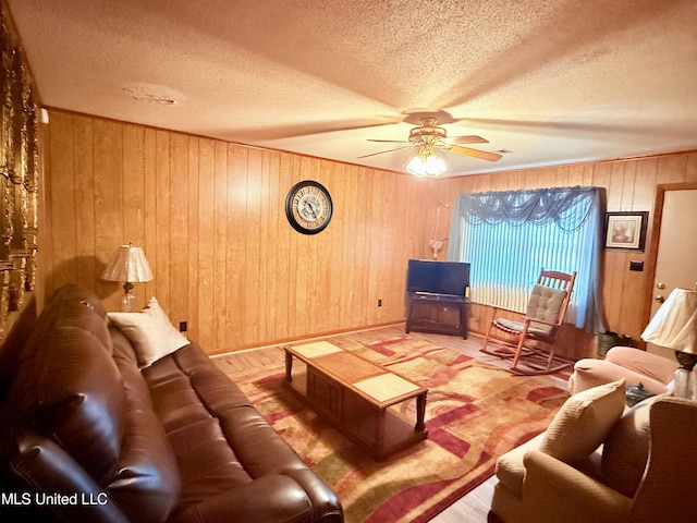 126 Lyon Dr, Grenada, MS 38901 - living room featuring wood-type flooring, wooden walls, a textured ceiling, and ceiling fan