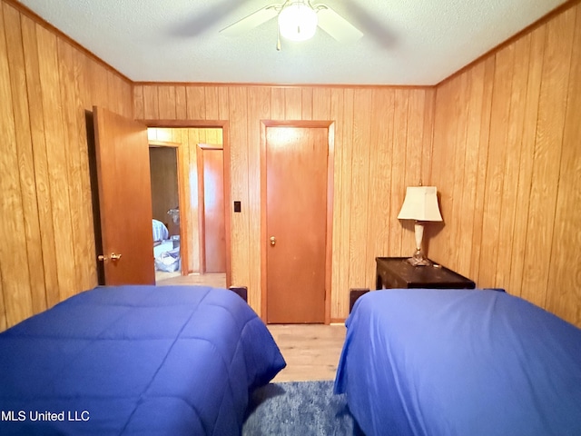 126 Lyon Dr, Grenada, MS 38901 - bedroom featuring ceiling fan, wooden walls, wood-type flooring, ornamental molding, and a textured ceiling
