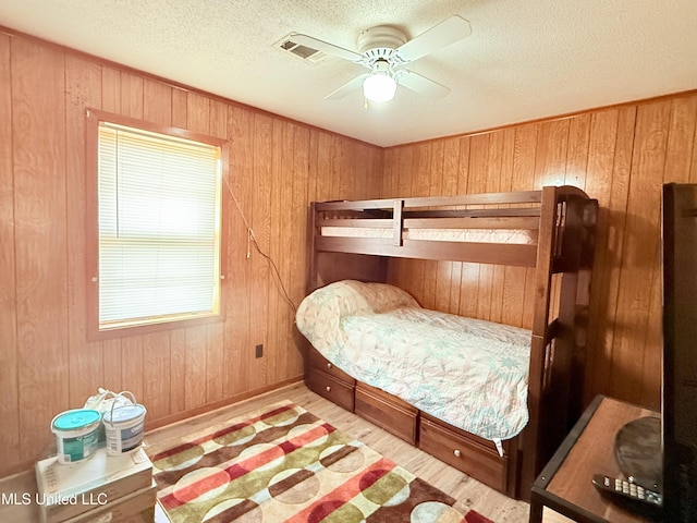 126 Lyon Dr, Grenada, MS 38901 - bedroom featuring wooden walls, a textured ceiling, and light hardwood / wood-style floors