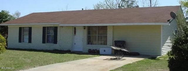 view of front facade with brick siding and a front lawn