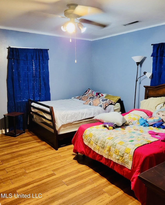 201 Seymour Dr, Indianola, MS 38751 - bedroom featuring wood finished floors, ornamental molding, ceiling fan, and visible vents
