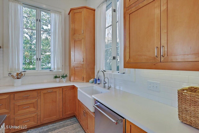 kitchen featuring decorative backsplash, sink, and stainless steel dishwasher