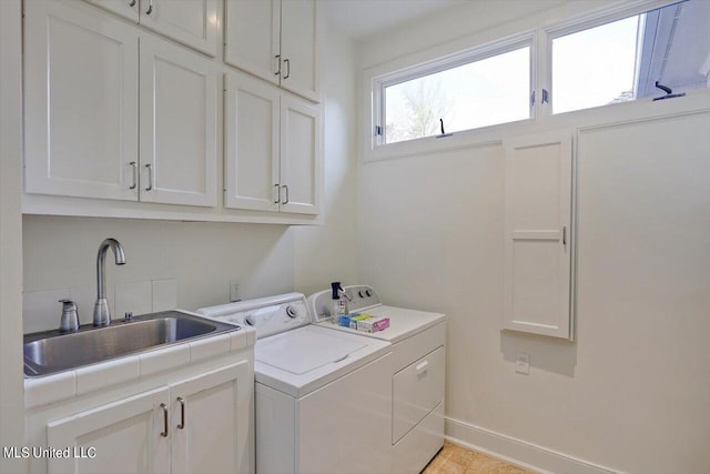 laundry area with sink, independent washer and dryer, and cabinets