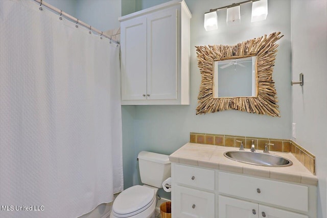 bathroom featuring toilet, vanity, and a shower with shower curtain