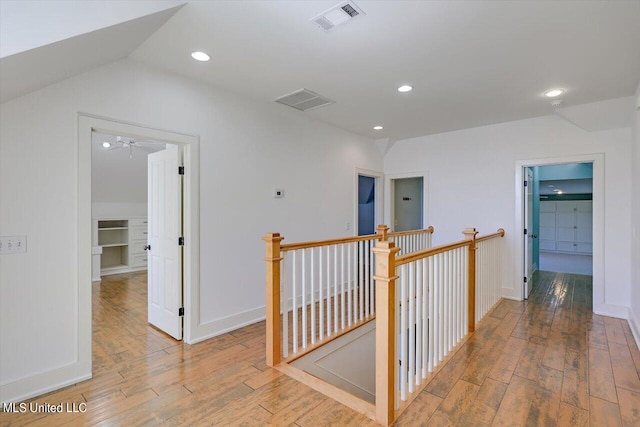 hall with light wood-type flooring and vaulted ceiling