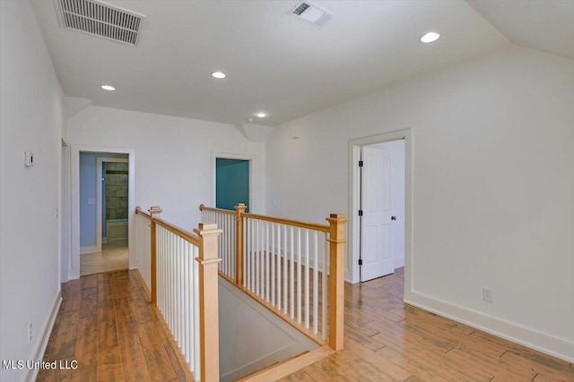 hallway featuring lofted ceiling and wood-type flooring