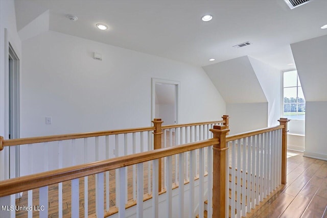 hall featuring lofted ceiling and hardwood / wood-style floors