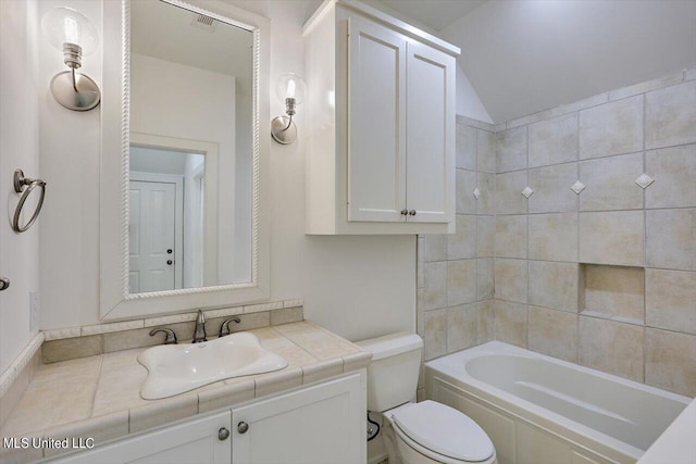 full bathroom with toilet, tiled shower / bath, and vanity