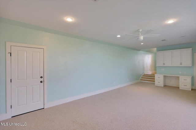 interior space with built in desk and ceiling fan