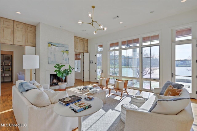 living room featuring a water view, a wealth of natural light, and light wood-type flooring