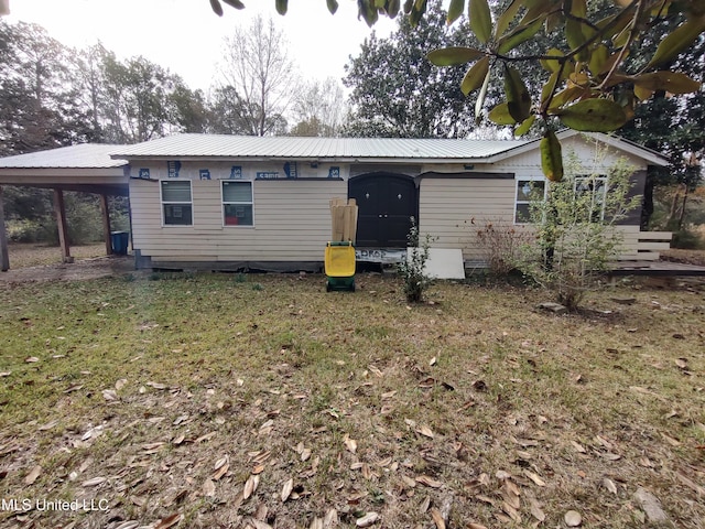 back of house featuring a yard and a carport