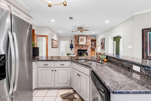 807 Woodglen Dr, Ocean Springs, MS 39564 - kitchen featuring stainless steel appliances, a sink, a ceiling fan, a brick fireplace, and recessed lighting