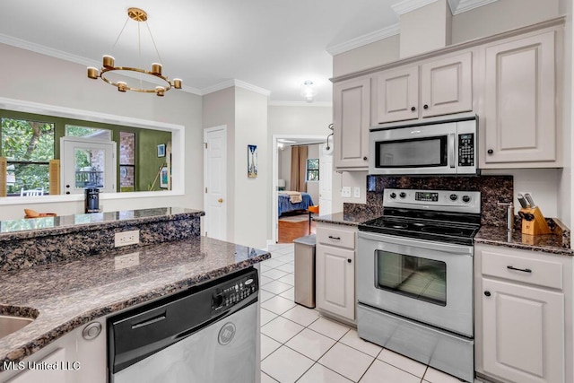 807 Woodglen Dr, Ocean Springs, MS 39564 - kitchen featuring appliances with stainless steel finishes, ornamental molding, light tile patterned floors, healthy amount of natural light, and dark stone countertops