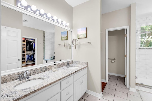807 Woodglen Dr, Ocean Springs, MS 39564 - full bath featuring double vanity, a walk in closet, a shower stall, tile patterned flooring, and baseboards