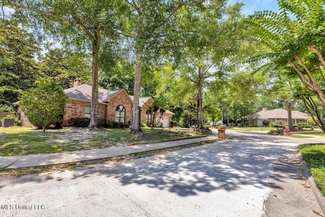 807 Woodglen Dr, Ocean Springs, MS 39564 - view of front facade with a chimney, brick siding, and central AC unit