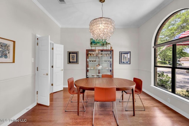 807 Woodglen Dr, Ocean Springs, MS 39564 - dining space with wood finished floors, a chandelier, ornamental molding, and baseboards