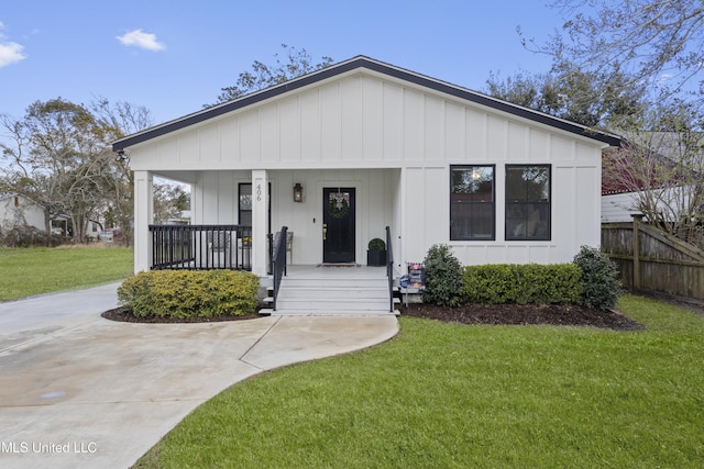 view of front of home featuring a porch, a front lawn, and board and batten siding