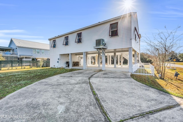 view of front facade with a carport, fence, and driveway