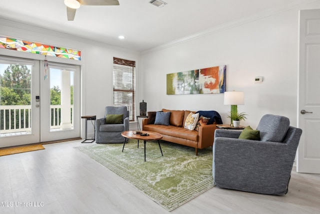 living room with french doors, wood finished floors, visible vents, and crown molding