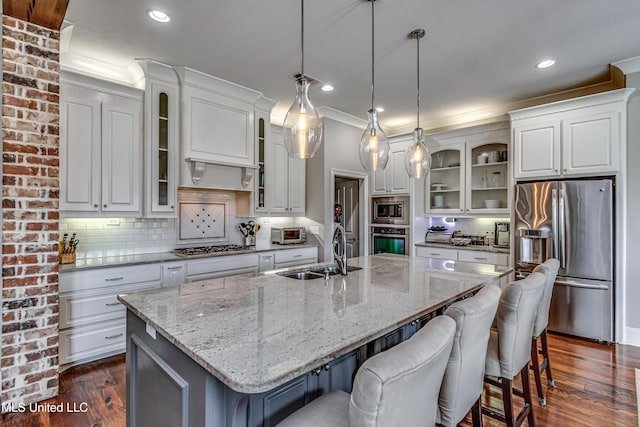 kitchen with backsplash, stainless steel appliances, white cabinets, and a sink