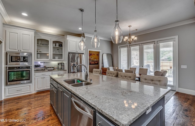 kitchen with a sink, crown molding, stainless steel appliances, and white cabinetry