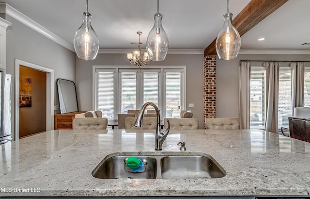 kitchen with a sink, a wealth of natural light, open floor plan, and ornamental molding
