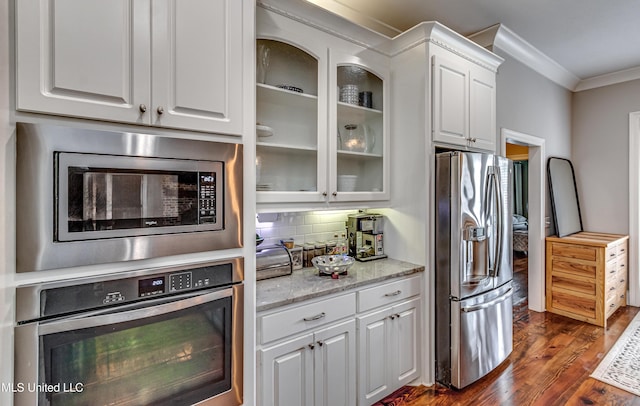 kitchen featuring crown molding, appliances with stainless steel finishes, dark wood-style flooring, and white cabinetry