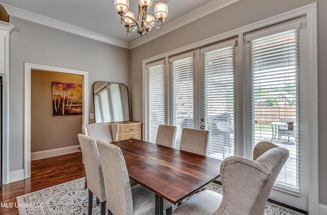 dining room with baseboards, ornamental molding, a notable chandelier, and dark wood-style floors