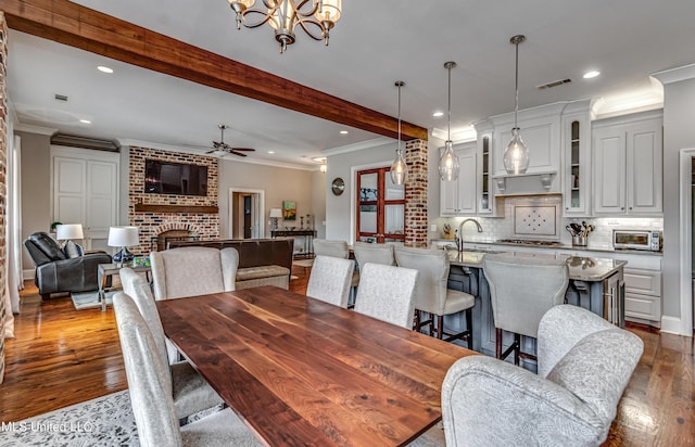 dining room with ceiling fan with notable chandelier, recessed lighting, dark wood-type flooring, visible vents, and ornamental molding