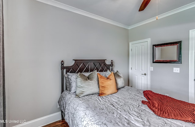 bedroom with crown molding, baseboards, ceiling fan, and wood finished floors