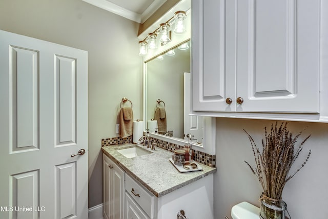 half bath featuring vanity, toilet, crown molding, and tasteful backsplash