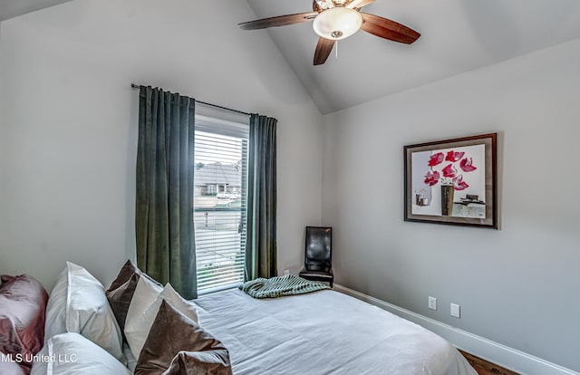 bedroom featuring baseboards, ceiling fan, wood finished floors, and high vaulted ceiling