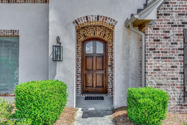entrance to property with brick siding and stucco siding