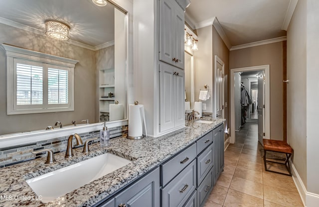 full bathroom with a sink, tile patterned flooring, ornamental molding, and double vanity