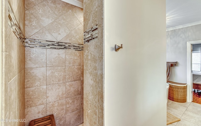 full bath featuring ornamental molding, tiled shower, and tile patterned flooring