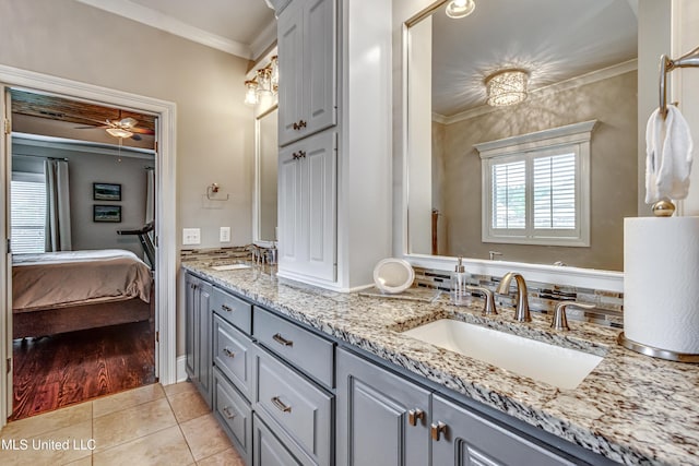 ensuite bathroom with a sink, double vanity, tile patterned floors, ensuite bathroom, and ornamental molding