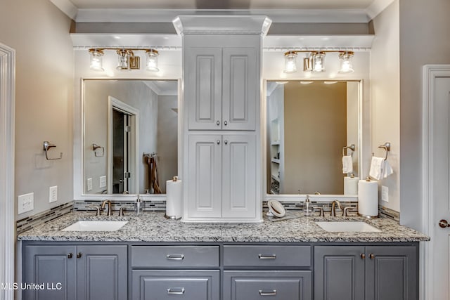 full bath featuring double vanity, a sink, and ornamental molding