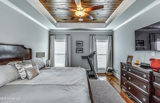 bedroom with baseboards, wooden ceiling, wood finished floors, and a raised ceiling