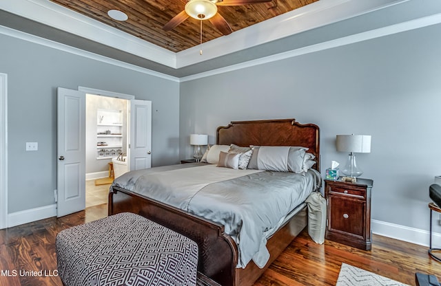 bedroom featuring a tray ceiling, wooden ceiling, baseboards, and wood finished floors