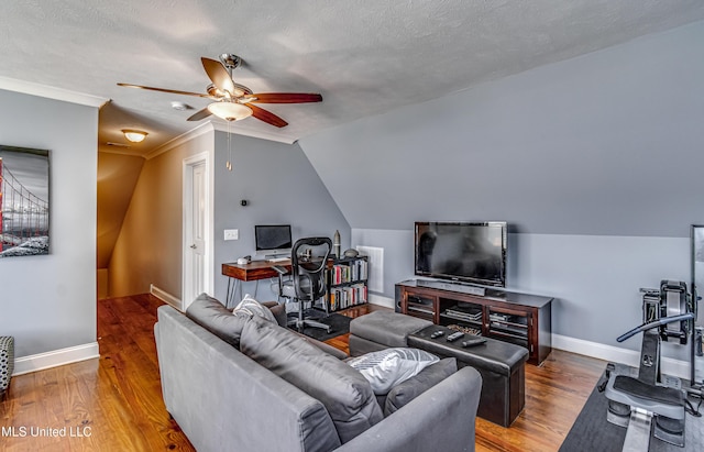 living area with baseboards, ceiling fan, wood finished floors, and vaulted ceiling