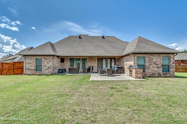 back of house with a patio, a fenced backyard, roof with shingles, brick siding, and a yard