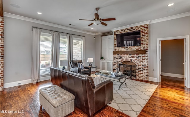 living area with a brick fireplace, a ceiling fan, baseboards, and wood finished floors
