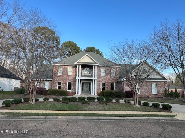 view of front of house with a balcony and a front yard