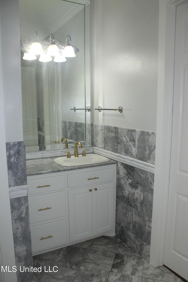 bathroom with vanity, ornamental molding, and tile walls