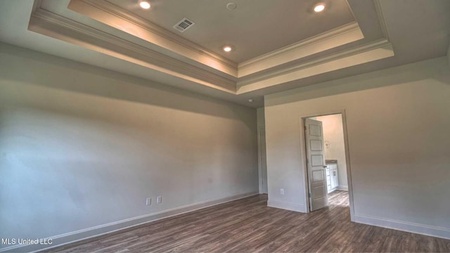 unfurnished room featuring crown molding, a raised ceiling, visible vents, baseboards, and dark wood finished floors